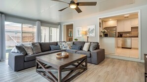 A modern living room with a sectional sofa, a wooden coffee table, and a ceiling fan. - Ponte Vedra Beach Vacation Rental w/ Private Pool! (Ponte Vedra Beach)