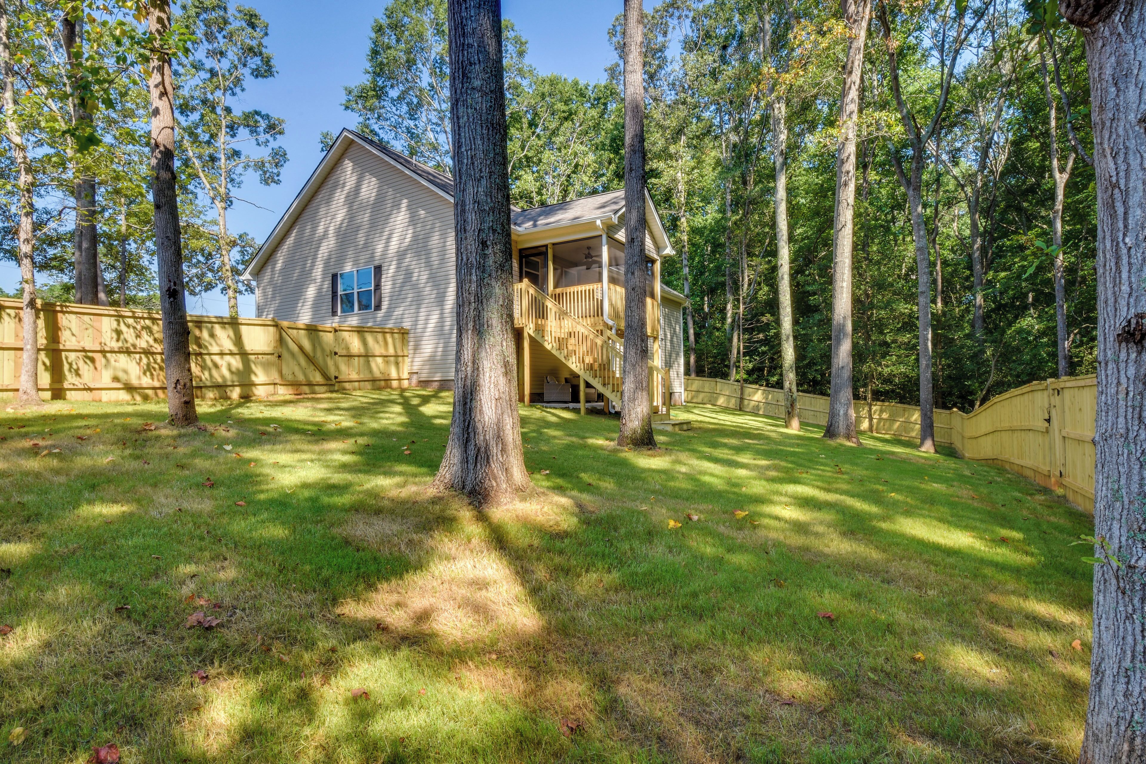 A two-story house with a wooden deck and a staircase leading to a second-floor balcony.