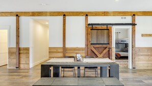 Un intérieur moderne avec une grande table en bois, deux chaises et une porte de grange rustique.