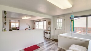 A spacious kitchen with a large island, a red rug, and a view of the backyard through a window. - Winchester Bay Vacation Rental Near Dunes & Atv! (Reedsport)