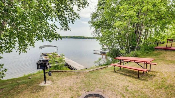 A lakeside picnic area with a grill, a fire pit, and a picnic table. - Pet-friendly Wisconsin Cabin on Lake w/ Fire Pit! (Townsend)