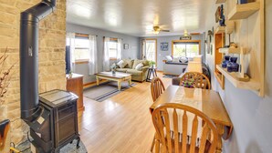 A cozy living room with a fireplace, a dining table, and a sofa. - Lakefront Wisconsin Home w/ Boat Dock & Fire Pit! (Townsend)