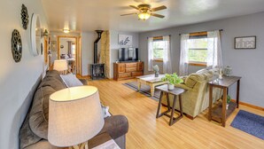 A spacious living area with a sofa, a coffee table, a TV, and a fireplace. - Lakefront Wisconsin Home w/ Boat Dock & Fire Pit! (Townsend)