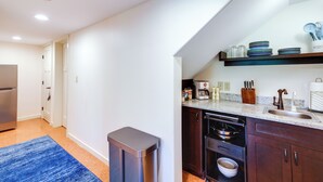 Una cucina moderna con lavastoviglie integrata, mobili in legno scuro e lavello in acciaio inossidabile.