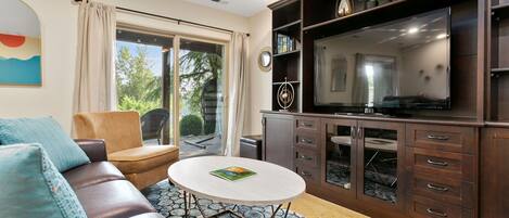 A living room with a sofa, a coffee table, a television, and a cabinet.
