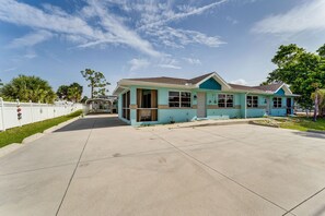 A two-story house with a front porch, a garage, and a driveway.