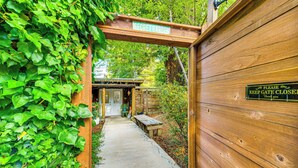 Una verja de madera con un letrero que dice 'SECRET GARDEN' y otro letrero que indica 'POR FAVOR, MANTENGA LA PUERTA CERRADA'.