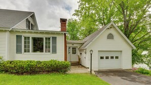 A two-story house with a garage, a front door, and a small porch. - Cape House in Farmington w/ Shared Outdoor Pool! (Farmington)