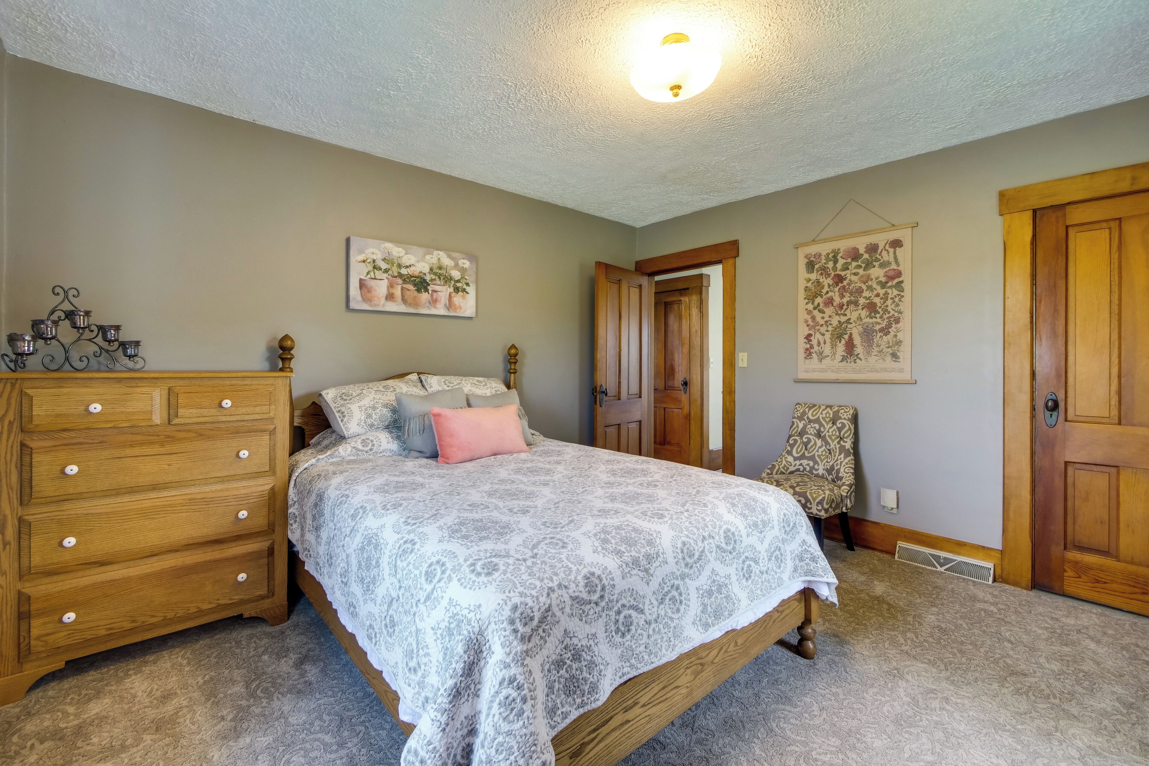 Une chambre à coucher avec un lit, une commode et deux portes.