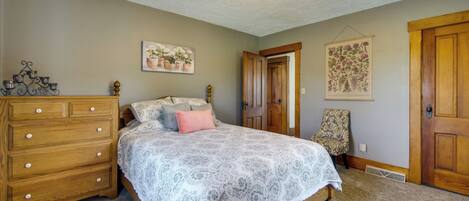 Une chambre à coucher avec un lit, une commode et deux portes.