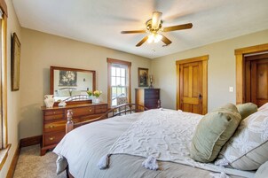 A bedroom with a bed, dresser, and a ceiling fan.