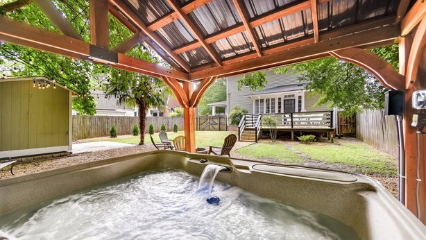 A hot tub under a wooden pergola with a backyard view. - Elizabeth City Vacation Rental: Gazebo w/ Hot Tub! (Elizabeth City)