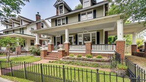 A two-story house with a front porch, brick columns, and a black iron fence. - Elizabeth City Vacation Rental: Gazebo w/ Hot Tub! (Elizabeth City)