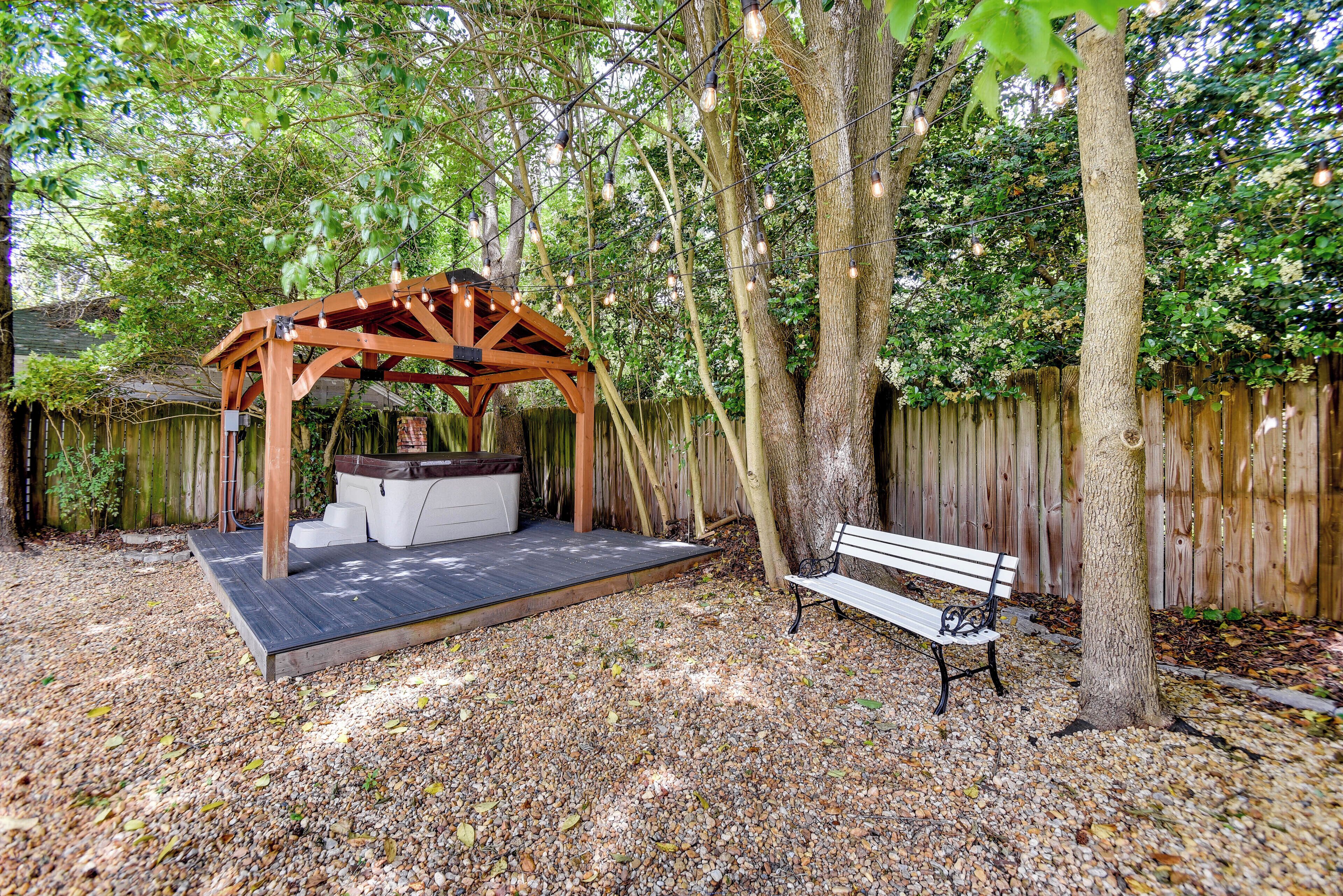 A wooden pergola with a built-in seating area and a bench.