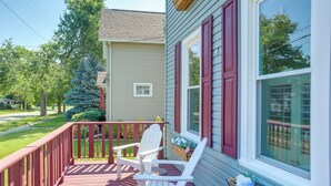 A wooden deck with two Adirondack chairs and a window with red shutters. - Vermilion Home - Walk to Main Street Beach! (Vermilion)