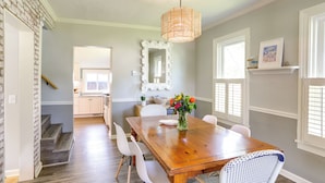 A dining room with a wooden table, white chairs, and a mirror on the wall. - Vermilion Home - Walk to Main Street Beach! (Vermilion)