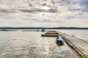 Une jetée en bois s’étendant dans une étendue d’eau calme, avec des bateaux amarrés à son extrémité.