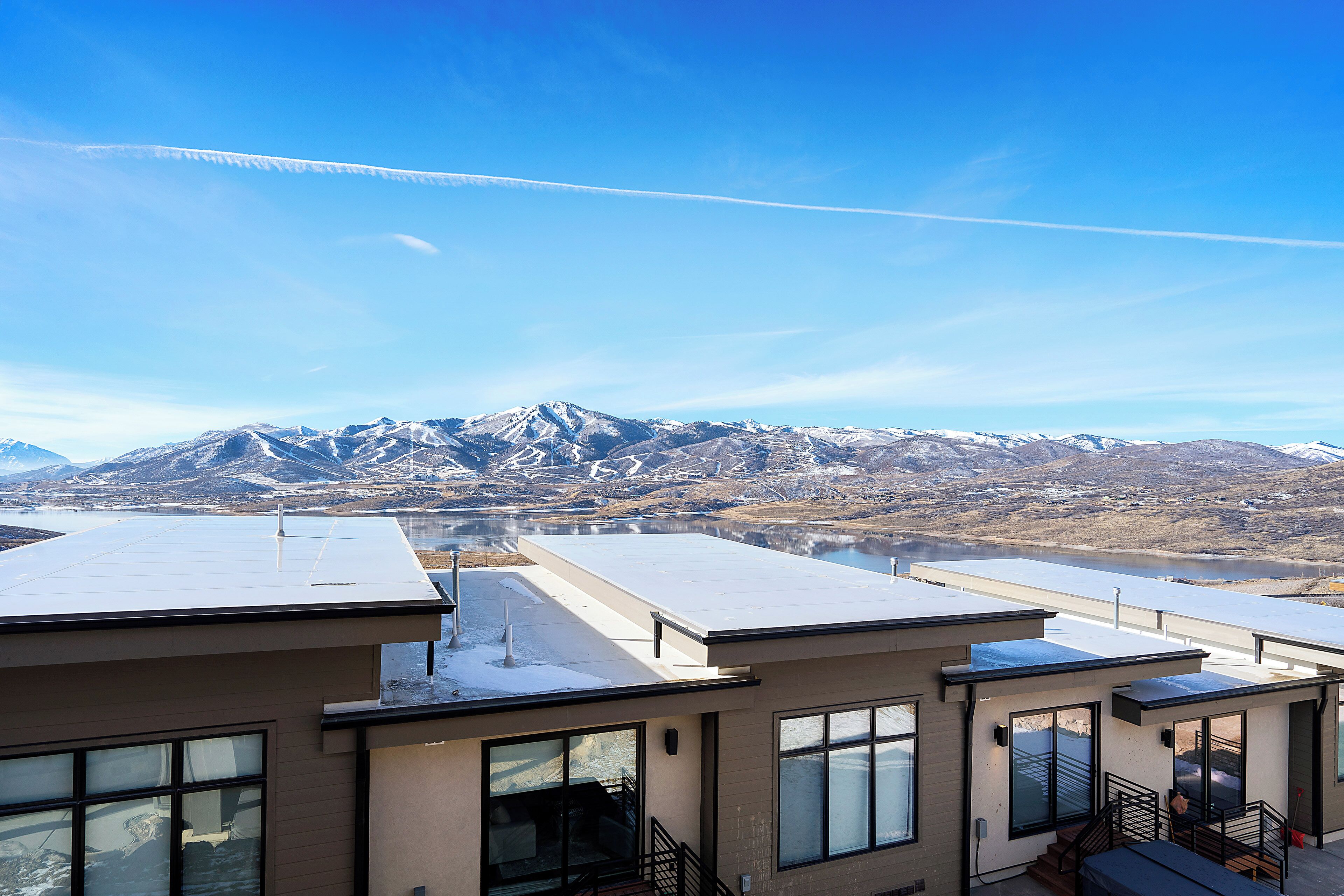 Un edificio moderno con amplios ventanales y vistas a montañas nevadas.