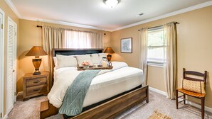 A bedroom with a bed, nightstands, a chair, and a window with curtains. - 'the Travis House at Lantern Springs' on Farm! (Lexington)