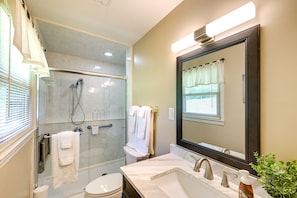 A bathroom with a glass-enclosed shower, a toilet, a sink with a mirror, and a potted plant. - 'the Travis House at Lantern Springs' on Farm! (Lexington)
