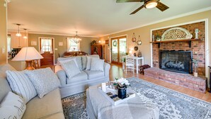 A cozy living room with a fireplace, a ceiling fan, and a dining area with a table and chairs. - 'the Travis House at Lantern Springs' on Farm! (Lexington)