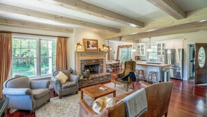 A spacious living room with a fireplace, comfortable seating, and a view of the outdoors. - Tranquil Wyoming Cabin Near Uintas - 105 Acres! (Evanston)