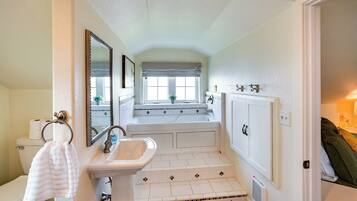 A bathroom with a white sink, a mirror, a toilet, and a bathtub.