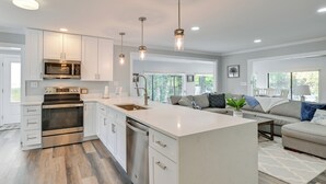 A modern kitchen with white cabinetry, stainless steel appliances, and a large island. - Spacious Lake Norman Retreat w/ Boat Ramp! (Sherrills Ford)