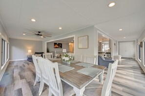 A spacious dining area with a wooden table and white chairs, a ceiling fan, recessed lighting, and a view into the kitchen. - Spacious Lake Norman Retreat w/ Boat Ramp! (Sherrills Ford)