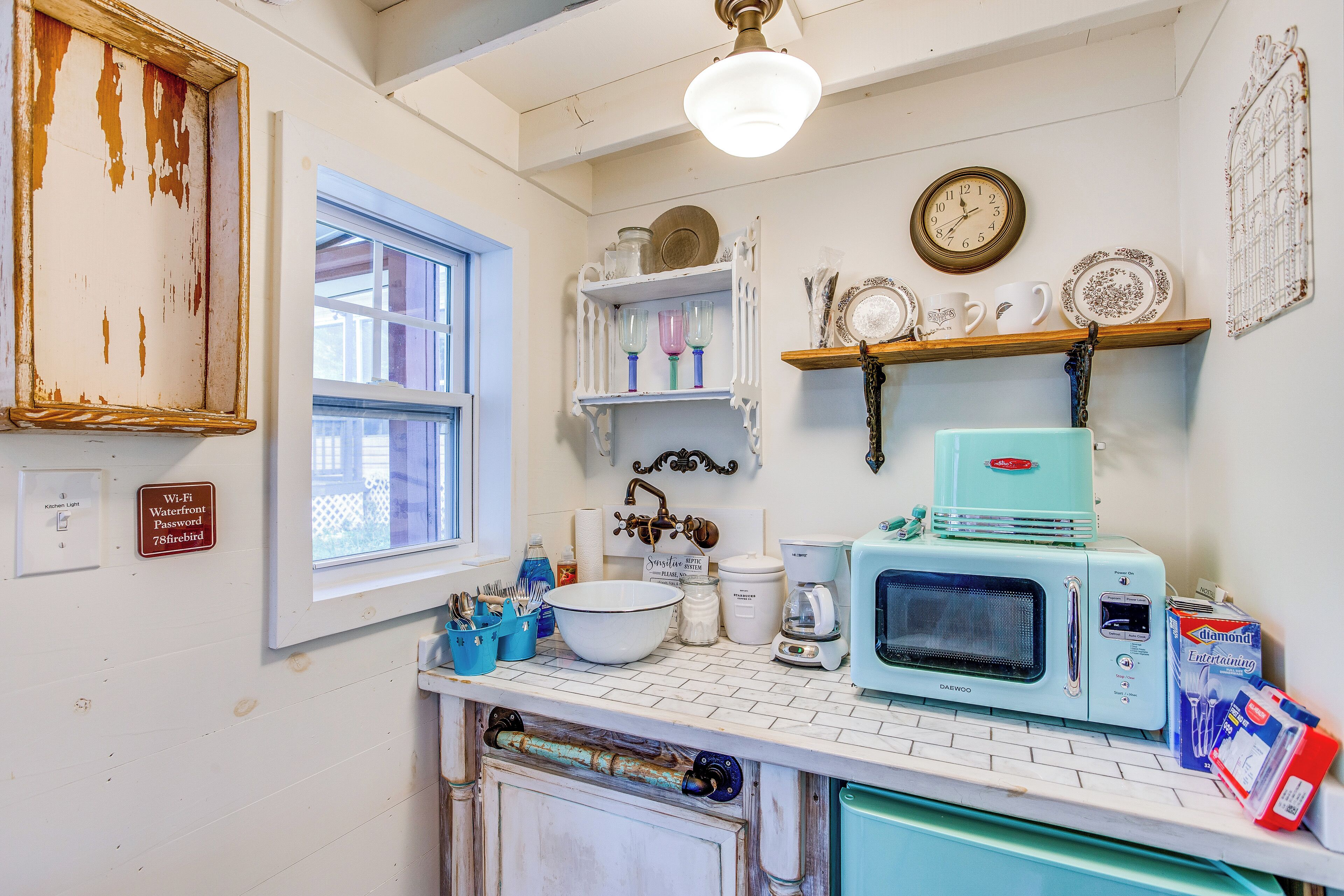 Una cocina con un microondas antiguo, una cafetera y un bol en la encimera.