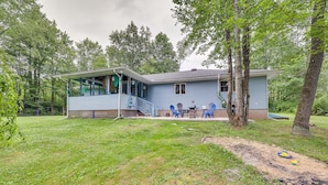 A two-story house with a porch, a small deck, and a backyard with a table and chairs.