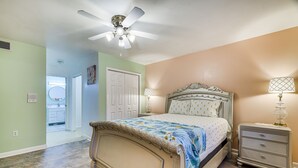 A bedroom with a bed, nightstand, and ceiling fan.