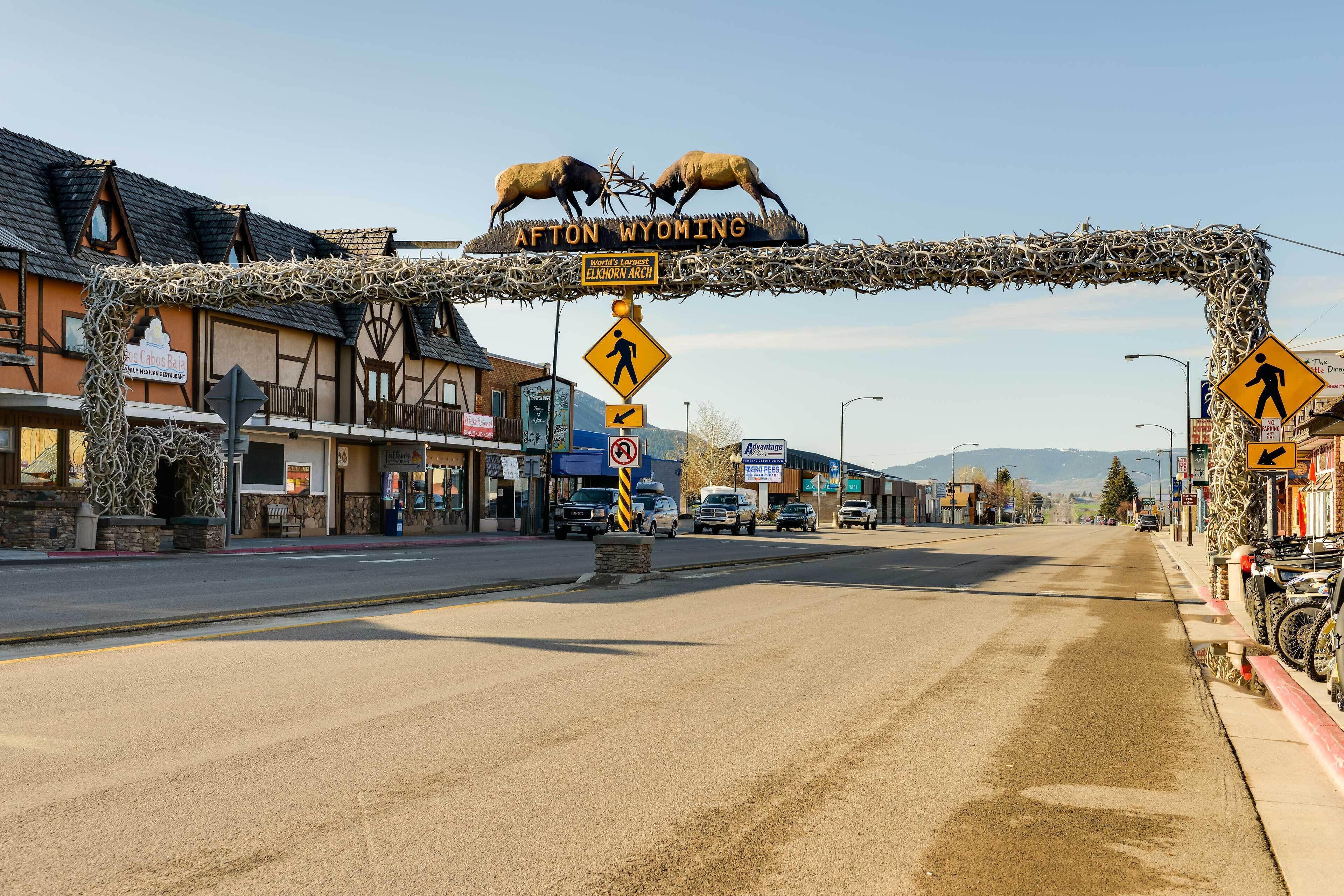 Une rue avec un panneau indiquant « Afton, Wyoming » et un panneau de passage piéton.
