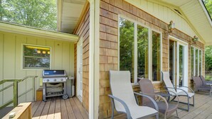 A wooden deck with outdoor seating and a barbecue grill.