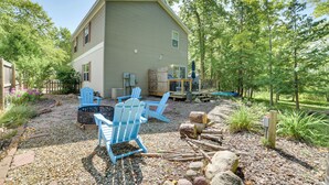 A house with a large deck, blue Adirondack chairs, and a fire pit. - Walloon Lake Getaway w/ Fire Pit - Walk to Water! (Walloon Lake)