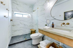 A bathroom with a toilet, sink, and shower.