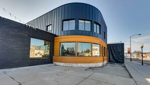 A modern building with a curved facade, large windows, and a wooden accent. - The Lofts on 89 Condo Near Bridger Nat'l Forest! (Afton)