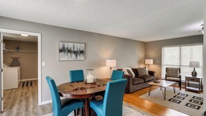 A dining area with a round table, teal chairs, and a candle centerpiece. - Rural Melbourne House With Deck! (Melbourne)