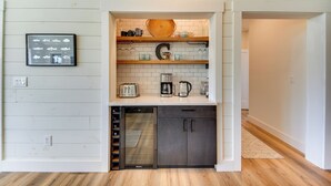 A compact kitchen with white cabinetry, a built-in oven, and a coffee maker on the countertop. - Stunning Chesapeake Bay Farmhouse w/ Dock & Kayaks (Machipongo)