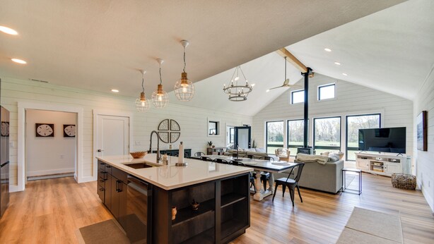A spacious kitchen with a large island, modern pendant lights, and a dining area with a sofa and chairs. - Stunning Chesapeake Bay Farmhouse w/ Dock & Kayaks (Machipongo)