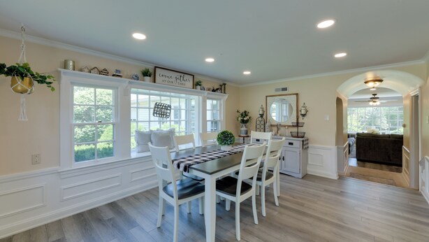 A dining area with a table, chairs, and a window with a view of greenery.