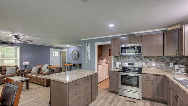 A modern kitchen with granite countertops, stainless steel appliances, and wooden cabinets.