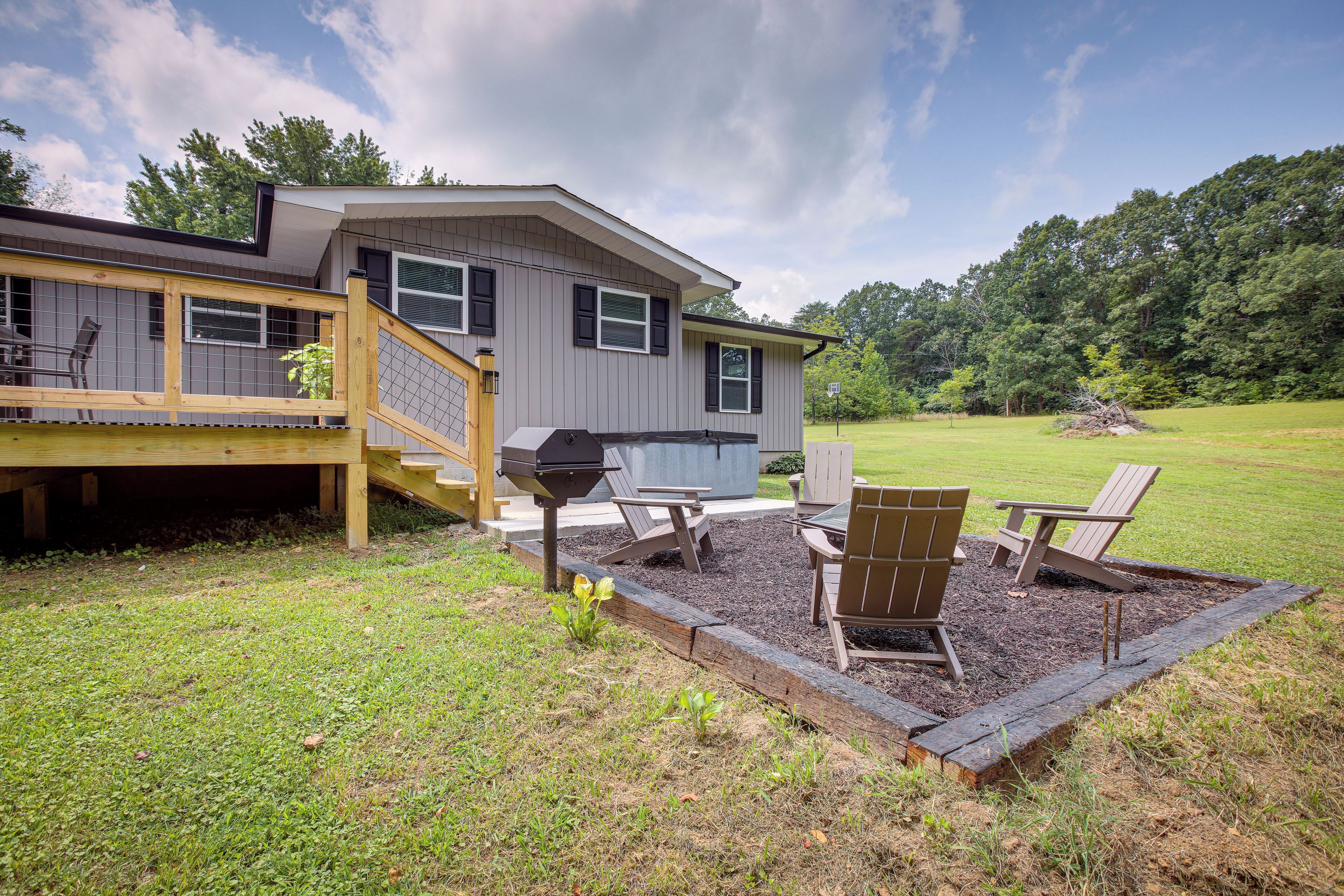 A house with a deck, outdoor seating, and a barbecue area.