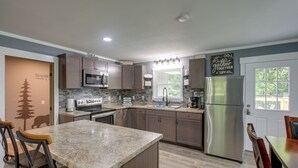 A modern kitchen with granite countertops, stainless steel appliances, and a breakfast bar.