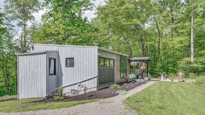 A single-story cabin with a gravel driveway and a small garden area. - Nature Lover's Cabin Inside Bully Hill State Park (Delevan)