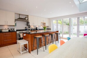 Enjoy cooking in this well-equipped kitchen with a central island and bar stools, offering a convenient dining space.