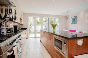 Enjoy cooking in this well-equipped kitchen with a central island, oven, and stainless steel range hood.