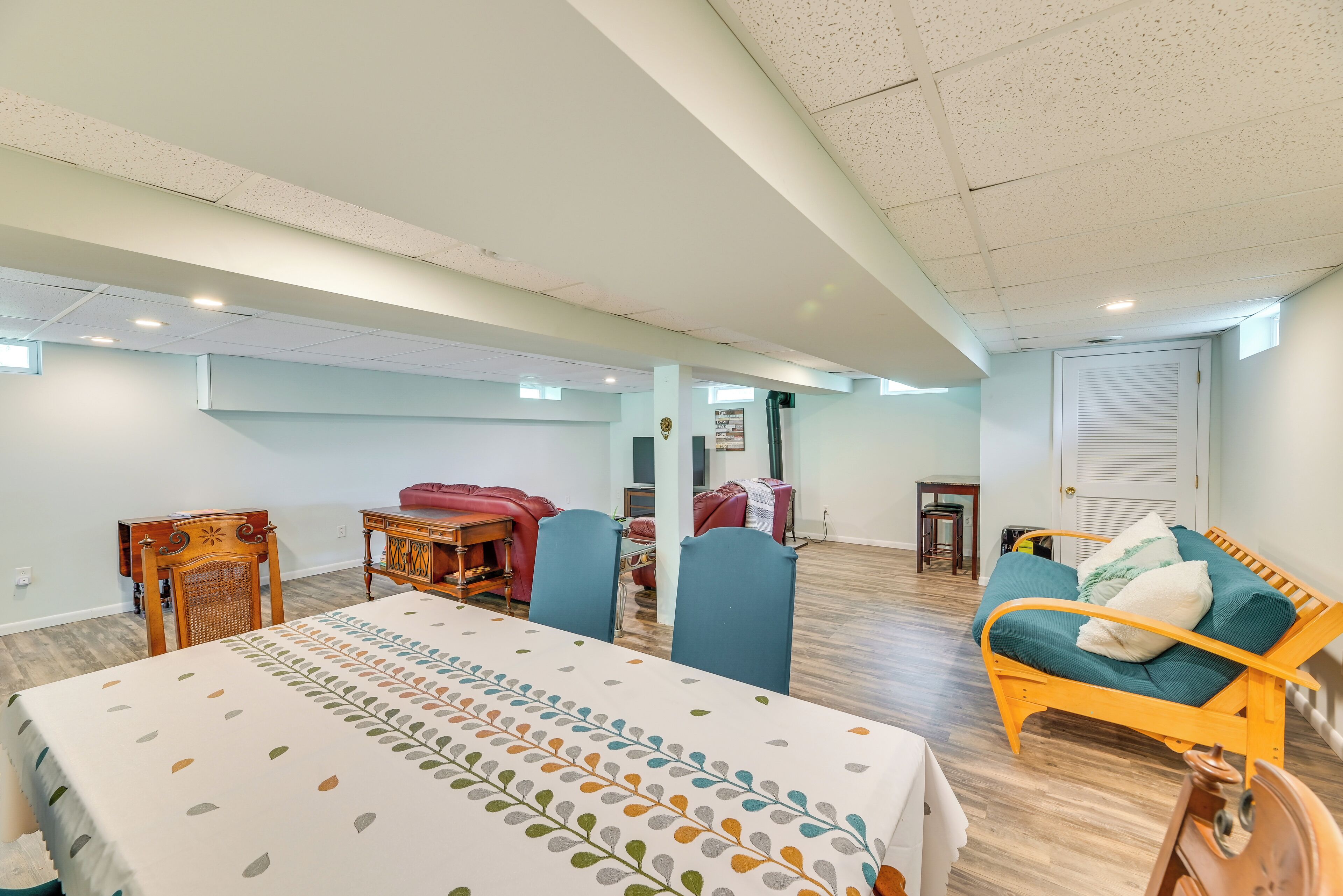 A spacious room with a large bed, a dining table, and a sofa.