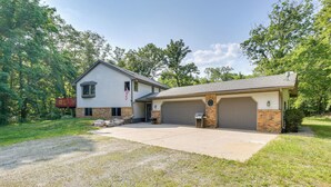 A two-story house with a garage, a front porch, and a brick exterior. - Faribault Home w/ Deck Near Cedar Lake Boat Ramp! (Faribault)