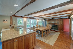 A kitchen with granite countertops, wooden cabinets, and a dining area with a wooden table and chairs. - Marlboro Escape: 9 Mi to Mount Snow Resort! (Wilmington)